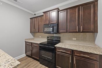 a kitchen with brown cabinets and a black stove top oven